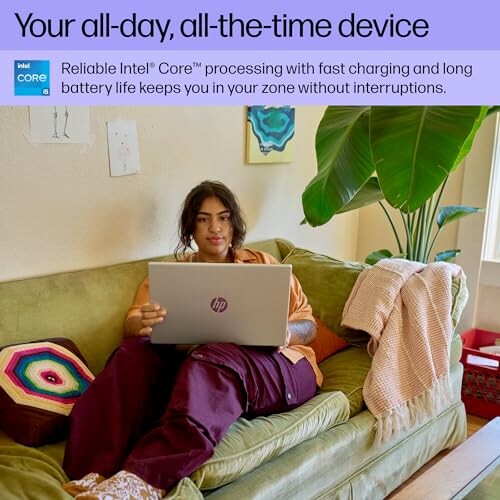 Person sitting on a couch using an HP laptop, surrounded by cushions and a plant.